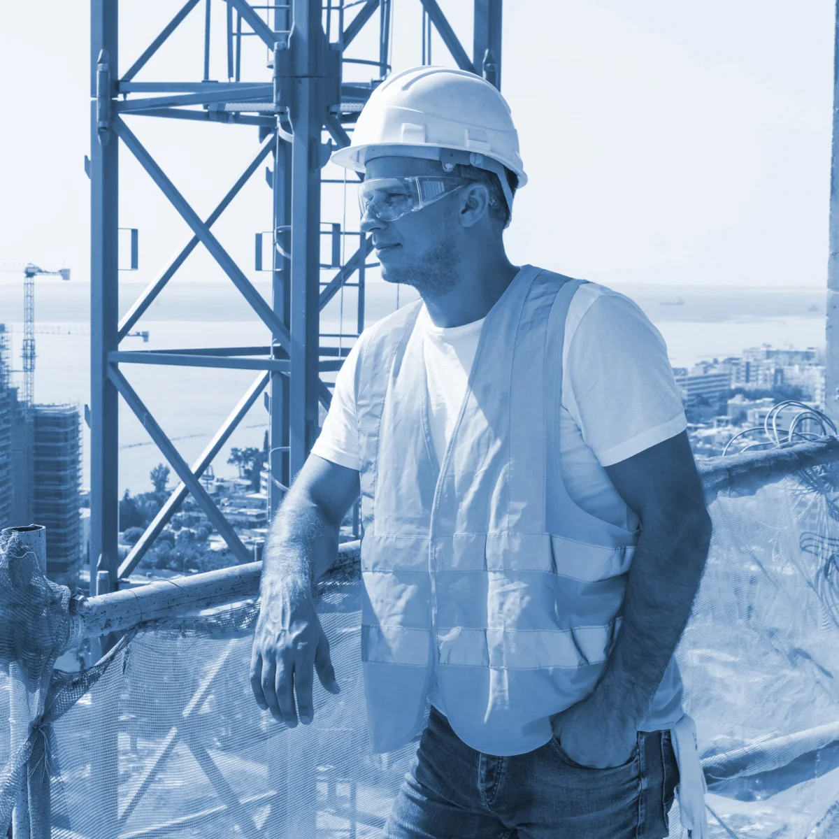 Empleado de construcción viendo una obra recargado en un barandal
